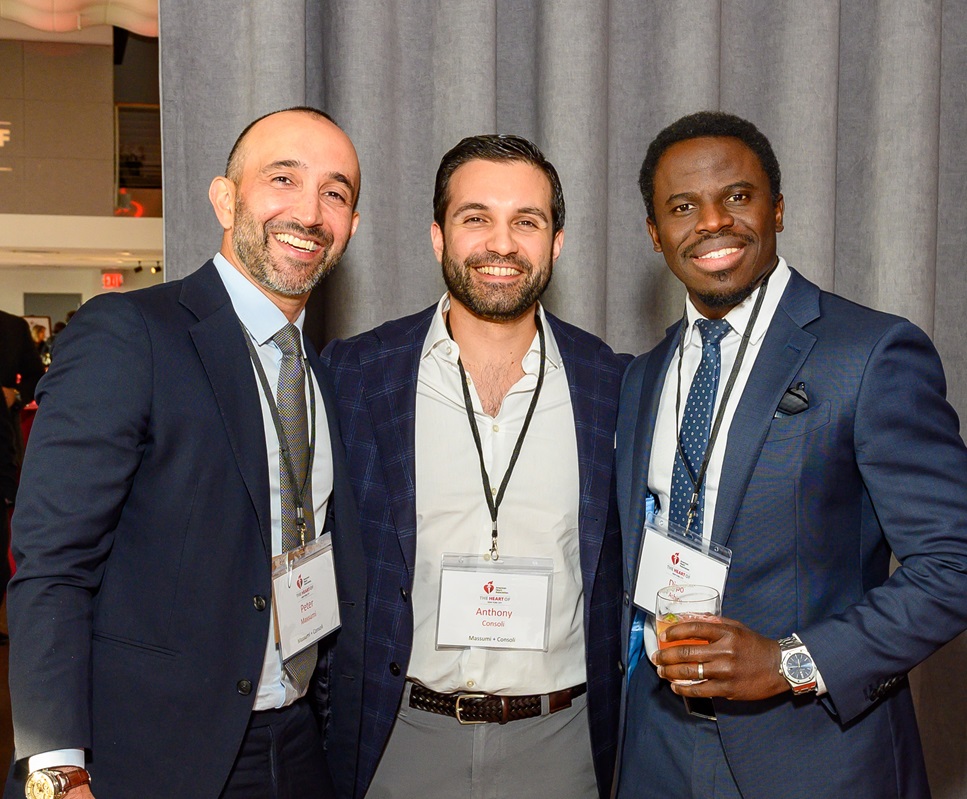Three men standing together smiling.